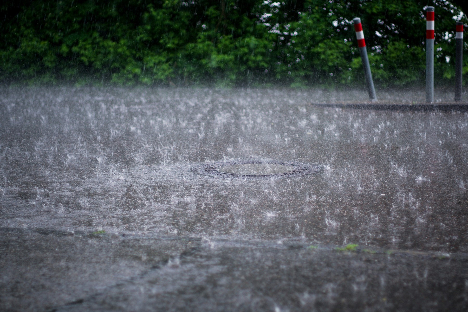 Starkregen auf Straße mit vollem Abfluss