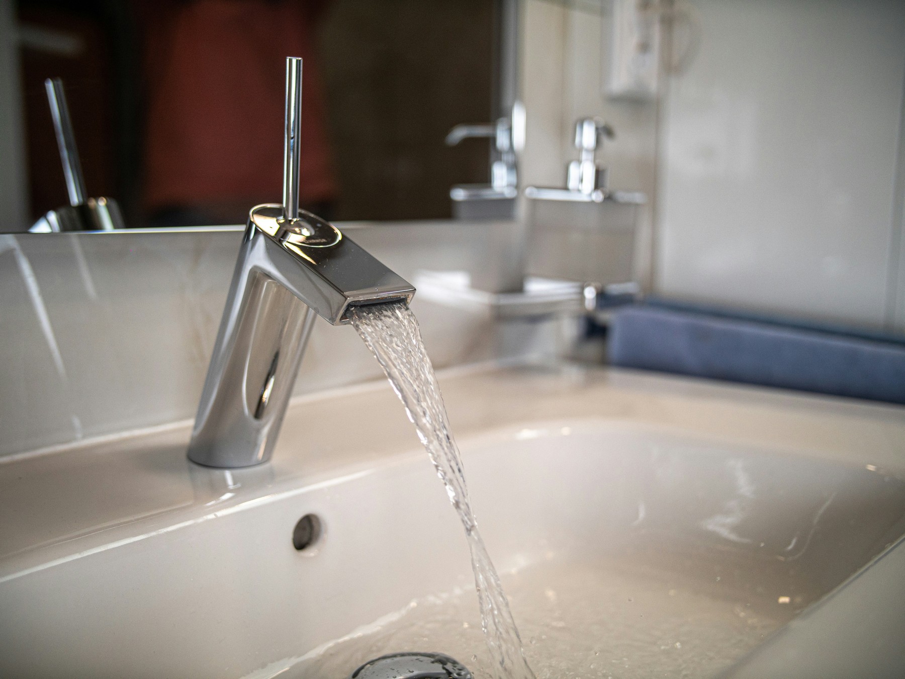 Wasser läuft in Waschbecken mit sichtbarem Abfluss