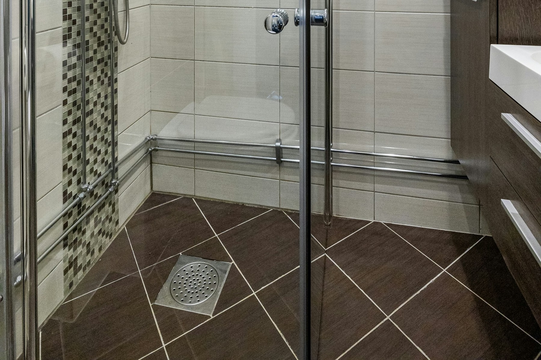 Pömpel auf Badezimmerboden neben Dusche